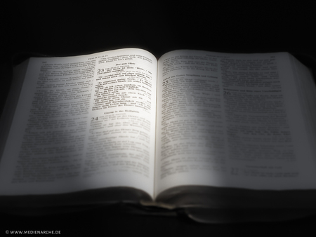 Bei Psalm 23 aufgeschlagene Bibel, leicht angeleuchtet, schwarz-weiss